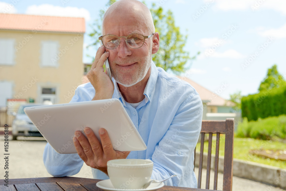 mature man use tablet . Sitting in the garden mature man use tablet . Sitting in the garden