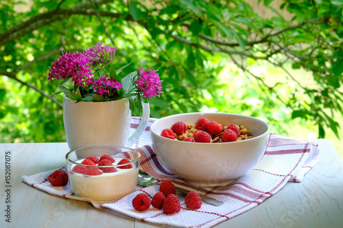 Breakfast with raspberries, yogurt and granola.