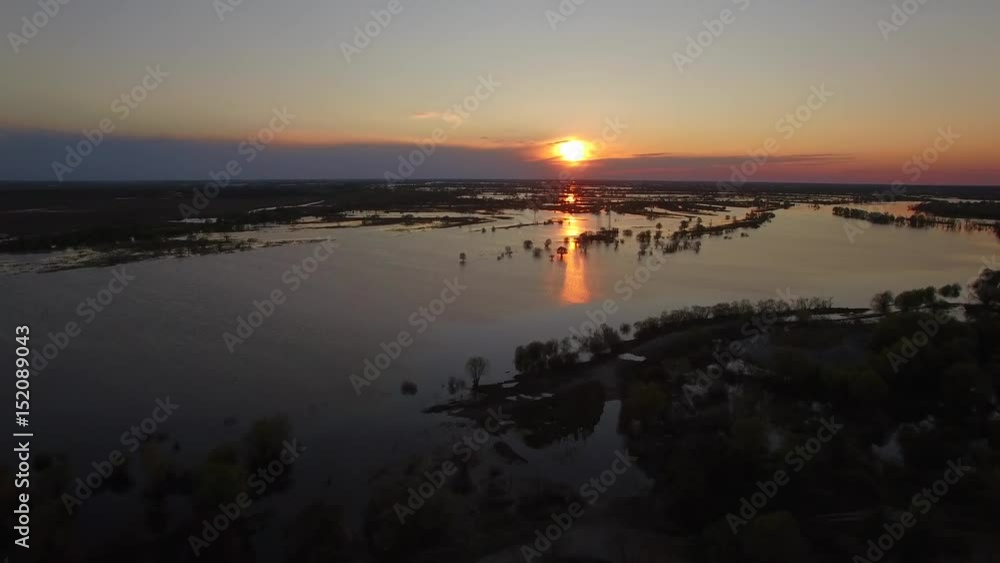 Flooded river in spring sunset 4k aerial top view. Fly above water overflowed banks of Pripiat filling bottomland or floodplain of fields in evening or morning golden hour in spring season, Belarus Flooded river in spring sunset 4k aerial top view. Fly above water overflowed banks of Pripiat filling bottomland or floodplain of fields in evening or morning golden hour in spring season, Belarus