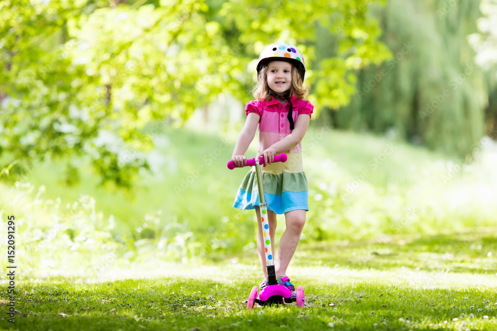 Little girl riding a colorful scooter Little girl riding a colorful scooter