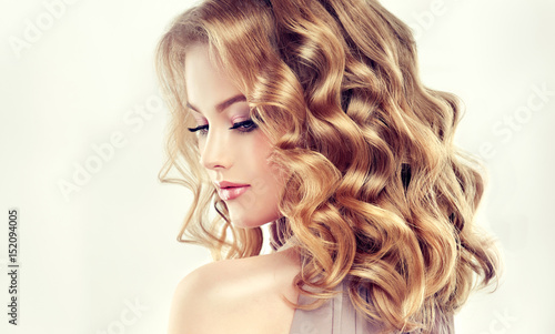 Beautiful blonde model girl with curly hair .Young woman with short wavy hairstyle