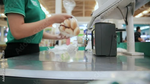 shopping, Friendly cashier behind checkout counter passing products to buyer