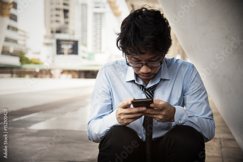 man worker is holding smartphone and using in feeling serious for something.