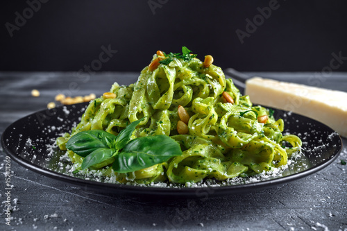 Canvastavla Tagliatelle pasta with pesto sauce, pine nuts and parmesan on black plate