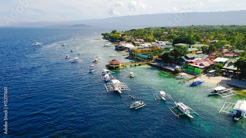 Aerial view of sandy beach with tourists swimming in beautiful clear sea water of the Sumilon island beach landing near Oslob, Cebu, Philippines. - Boost up color Processing.