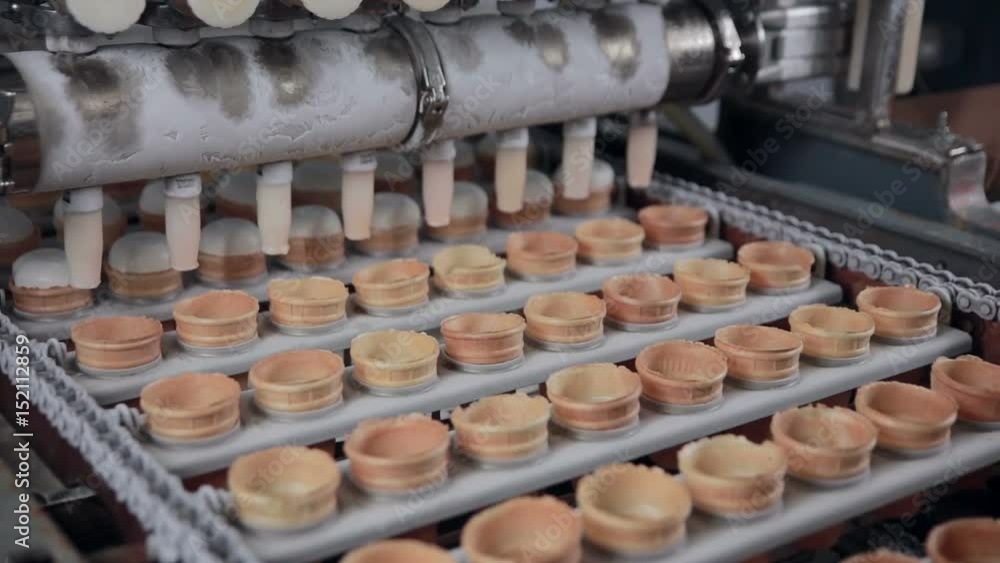 The ice-cream cones filled with ice-cream by the machine. Close-up. HD. The ice-cream cones filled with ice-cream by the machine. Close-up. HD.