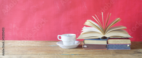 open book and cup of coffee on red background,free copy space