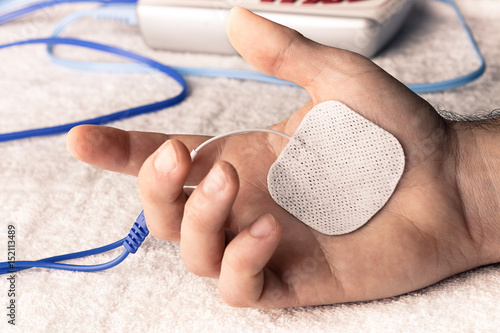 Electroestimulacion deportiva del dolor agudo de la mano a consecuencia del móvil photo