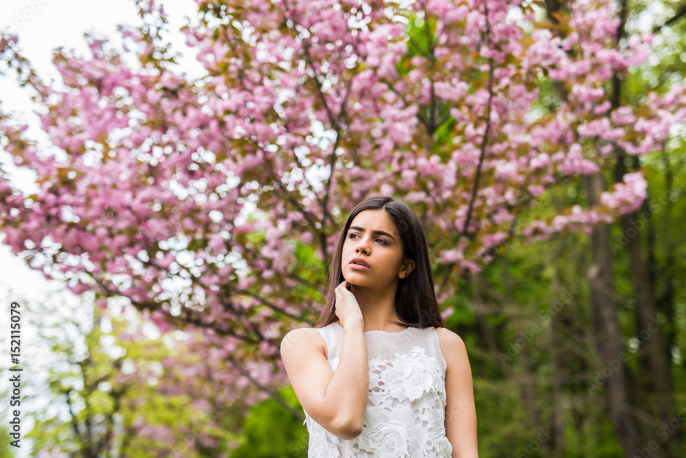 Fototapeta premium Spring beauty girl outdoors near Bbooming sakura tree.