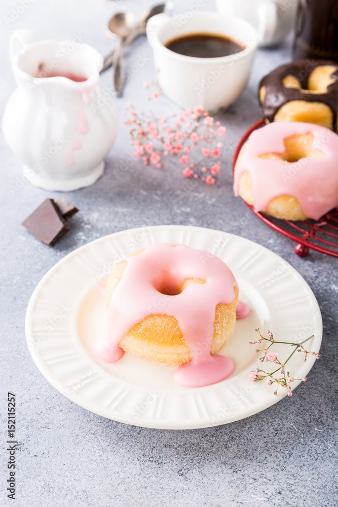 Delicious donuts with pink glaze on light gray background. Selective focus. Copy space. Delicious donuts with pink glaze on light gray background. Selective focus. Copy space.