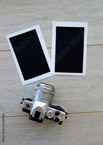 Blank photo frames, camera and supplies on wooden table. Top view. space for text