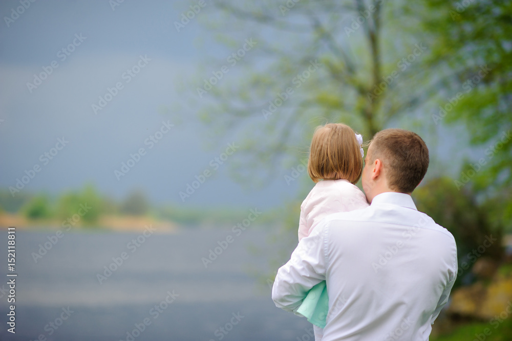 father with the little daughter walk on the river bank, look in a distance and reflect father with the little daughter walk on the river bank, look in a distance and reflect