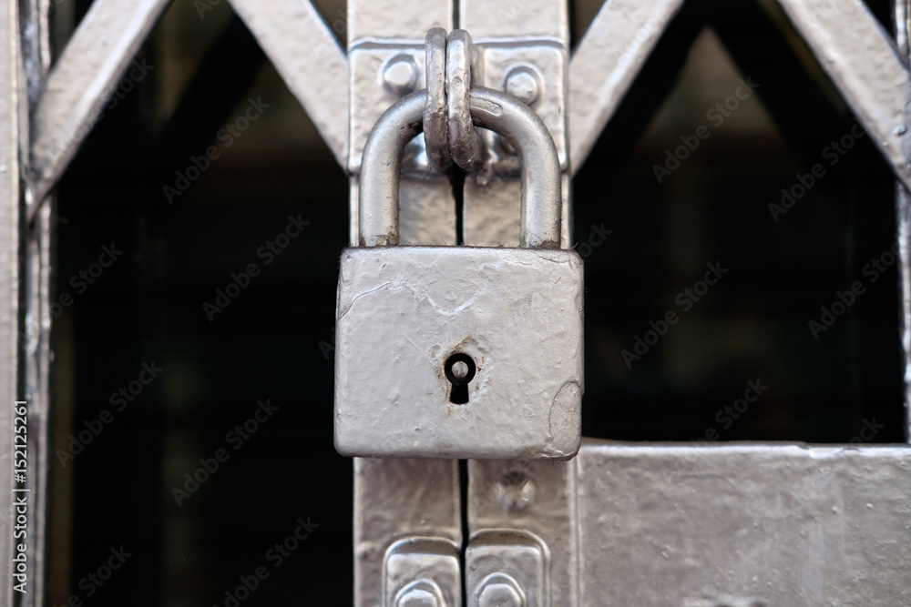 Fototapeta premium Old silver color metal lock on the gate.