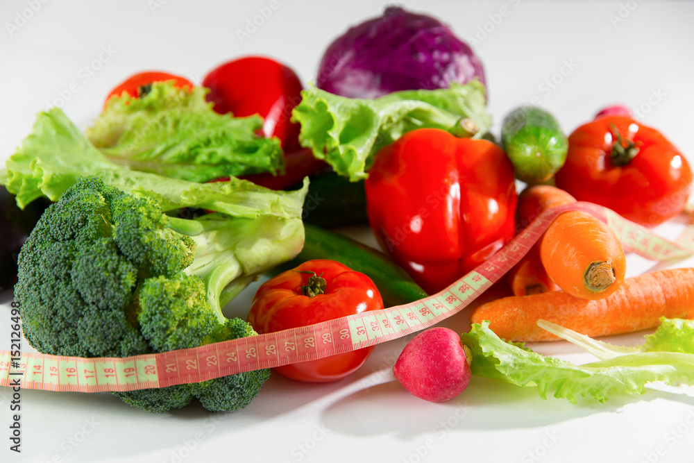 Vegetables and measuring tape, still life isolated on white background. Vegetables and measuring tape, still life isolated on white background.