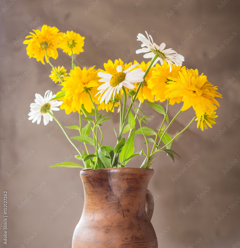 ceramic vase with yellow summer meadow flowers bouquet