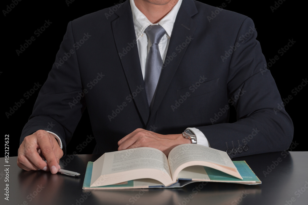 Businessman sitting at meeting room to open the business book isolated on black background as business and Learning concept. Businessman sitting at meeting room to open the business book isolated on black background as business and Learning concept.