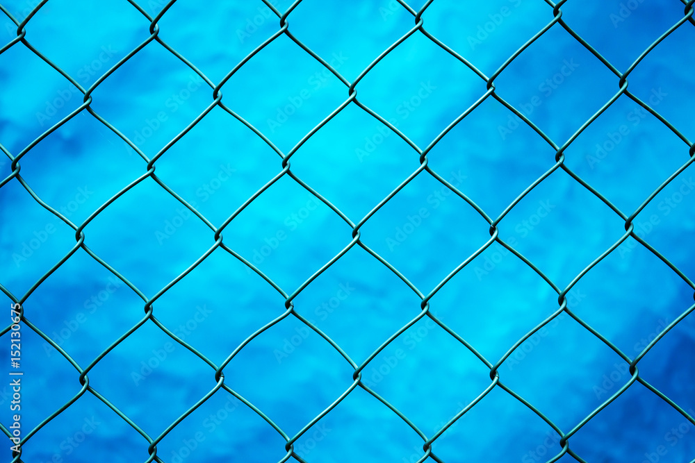 Fototapeta premium Green metal web on blue background