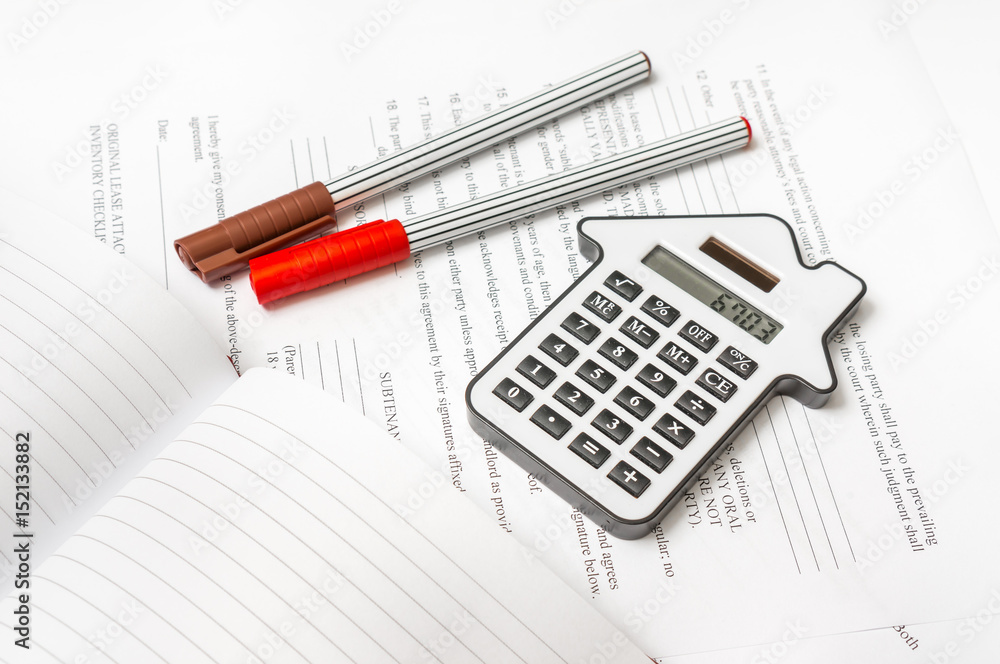 Calculator and contract - mortgage and real estate concept Calculator and contract - mortgage and real estate concept