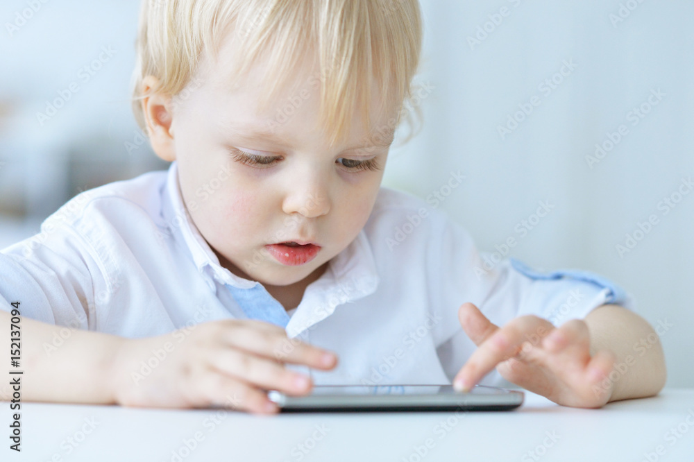 Boy is playing with a mobile phone Boy is playing with a mobile phone