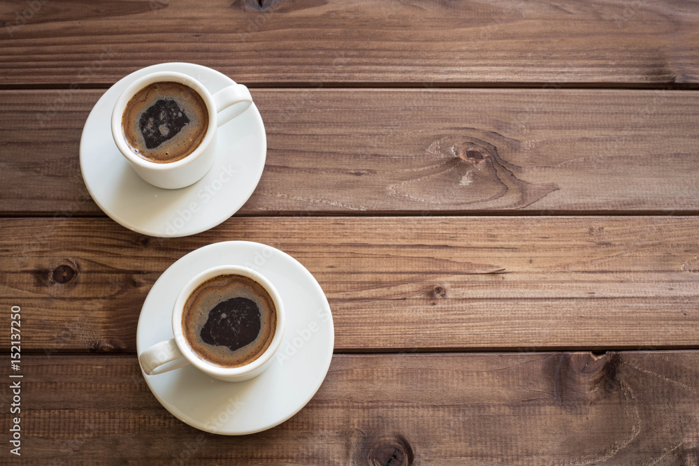 View of the two cup of coffee on the wooden table with place for inscription View of the two cup of coffee on the wooden table with place for inscription