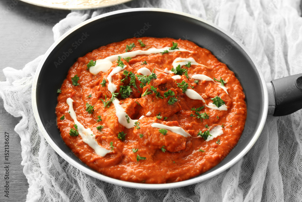 Murgh Makhani in frying pan on table Murgh Makhani in frying pan on table