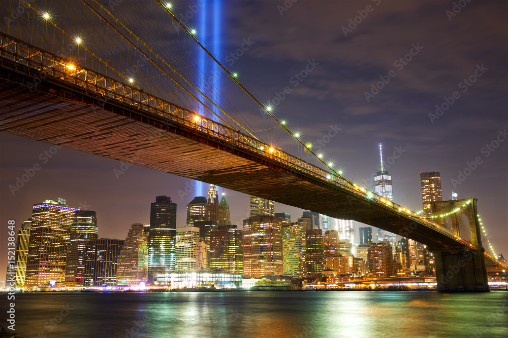 Brooklyn Bridge and Manhattan skyline with light beams