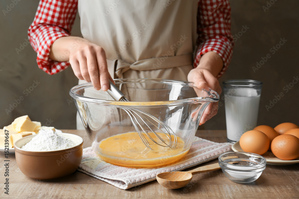 Woman making dough for a pie in bowl on table Woman making dough for a pie in bowl on table