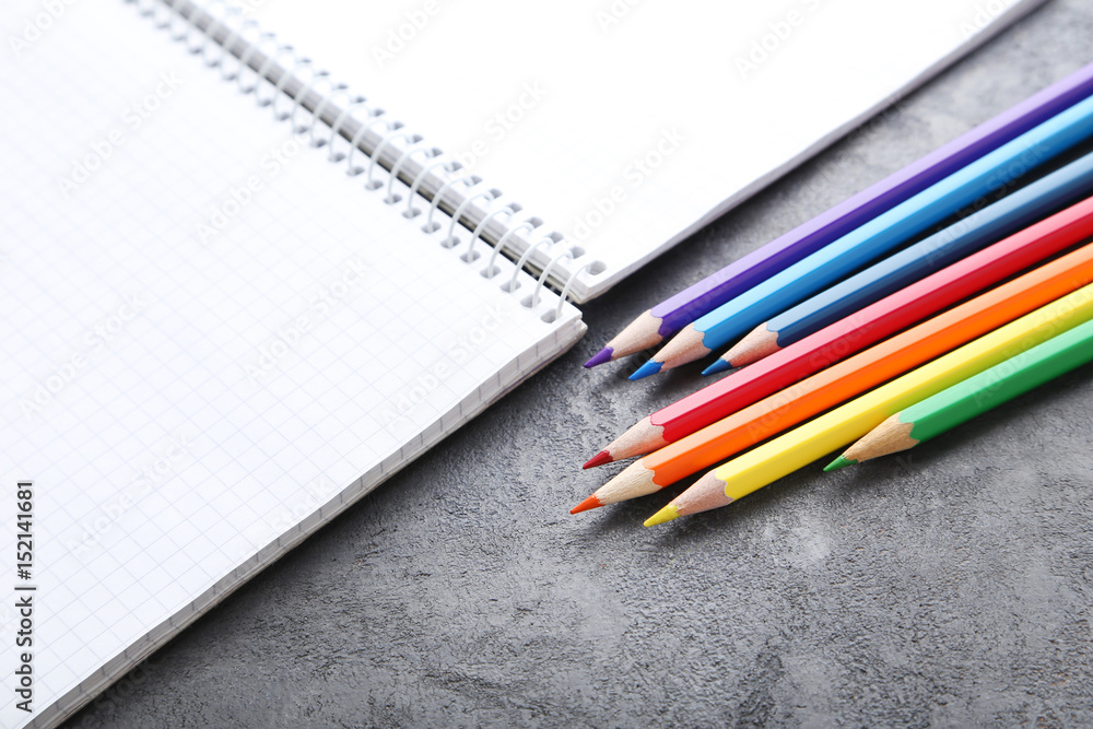 Drawing colourful pencils with notebook on grey wooden table Drawing colourful pencils with notebook on grey wooden table