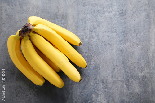 Sweet bananas on grey wooden table