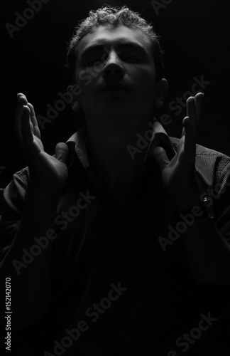 Photo of a man who raised his hands in prayer and closed his eyes