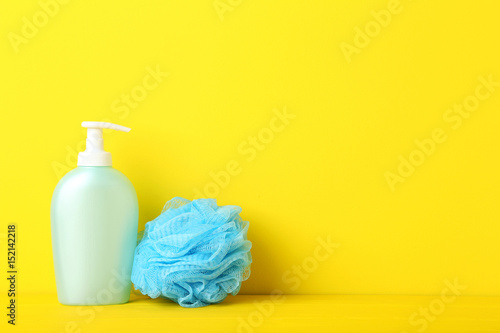 Cosmetic bottle with wisp on yellow background