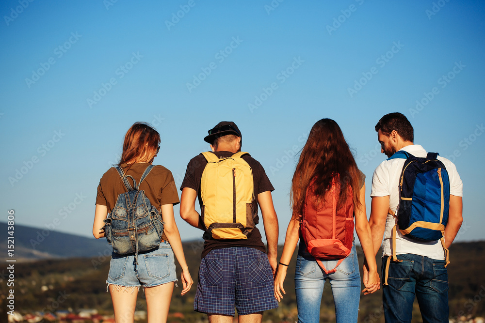 Friends watching idyllic landscape on mountain top on blue sky Friends watching idyllic landscape on mountain top on blue sky