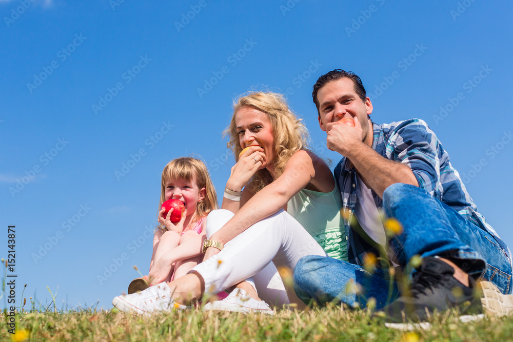 Parents and daughter eating apples