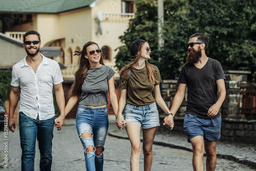 summer leisure of happy, smiling friends walking along brick road © Volodymyr