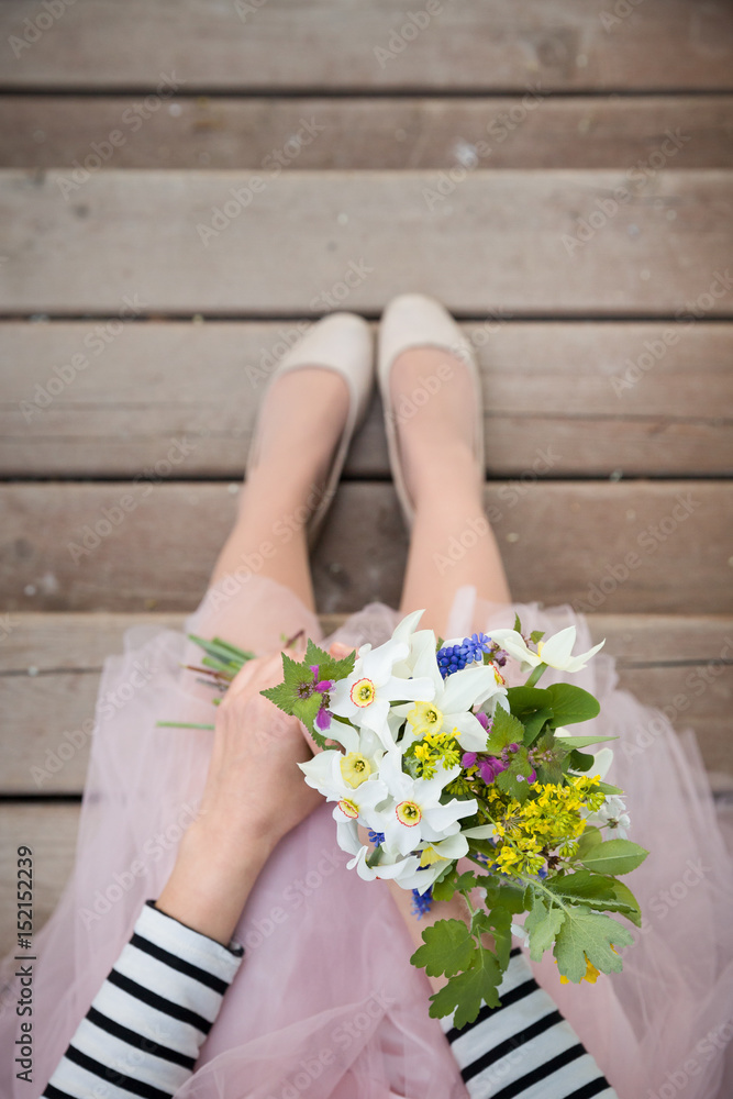 Top view on woman holding beautiful bunch of spring flowers. Girl with bouquet of daffodils, apple tree flowers and other garden flowers. Summer and spring concept. Selective focus. Top view on woman holding beautiful bunch of spring flowers. Girl with bouquet of daffodils, apple tree flowers and other garden flowers. Summer and spring concept. Selective focus.