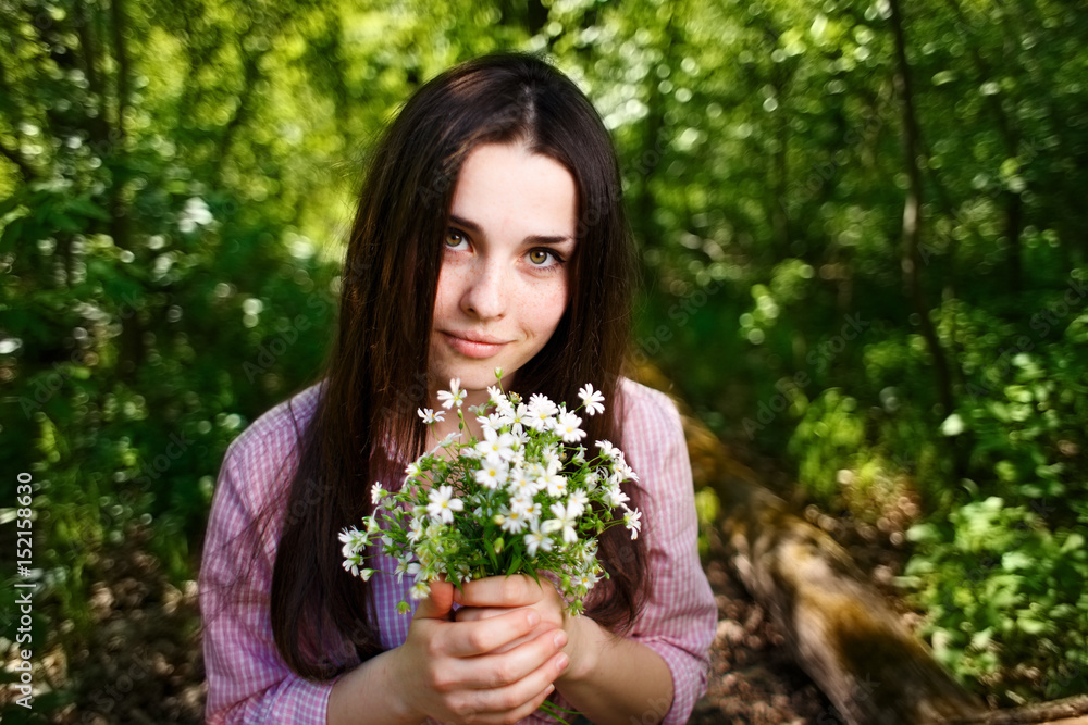 Young cute smiling woman with a bouquet of petite forest flowers Young cute smiling woman with a bouquet of petite forest flowers