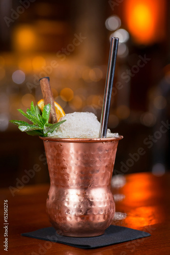 Cocktail. Mint Julep with orange in copper glass and steel straw