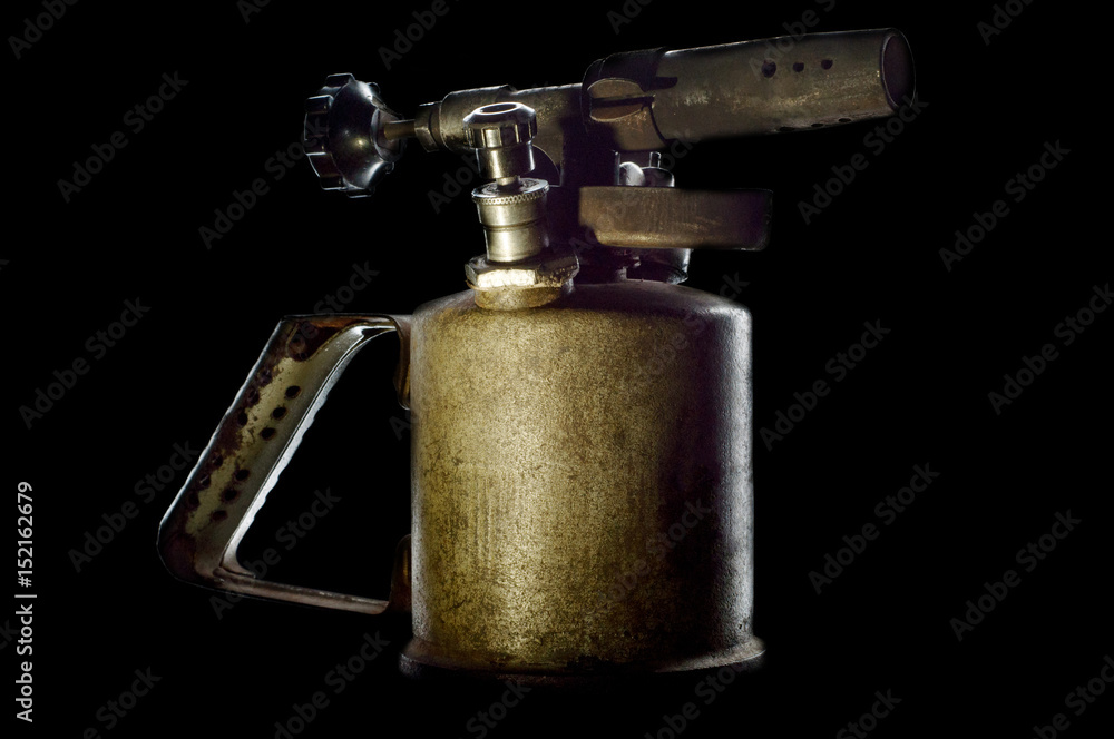 Old petrol blowtorch on a black background