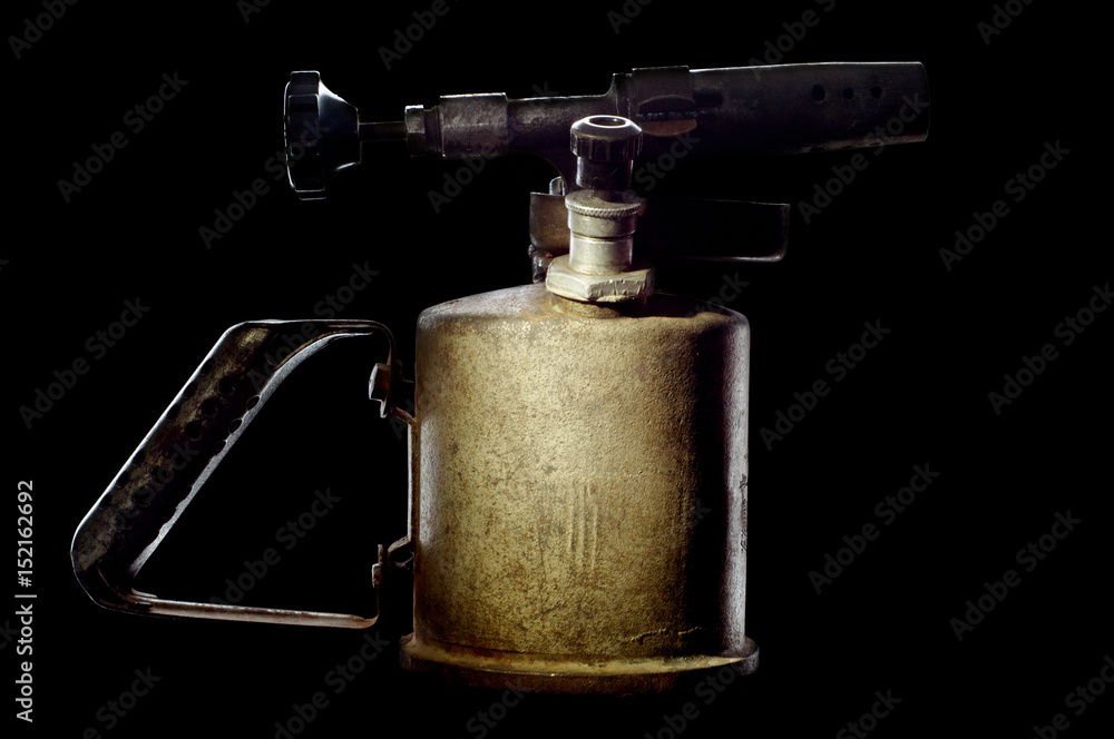 Old petrol blowtorch on a black background