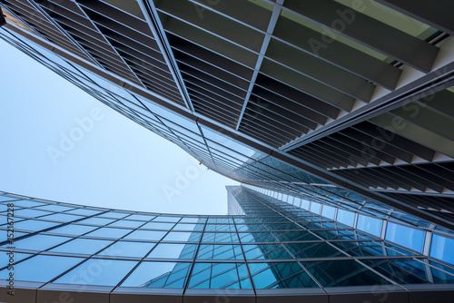 Modern and visionary skyscraper with many windows and reflections and blue sky