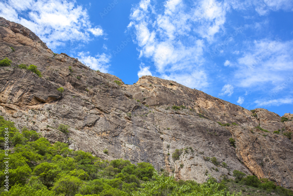 rocks is situated against blue sky background.