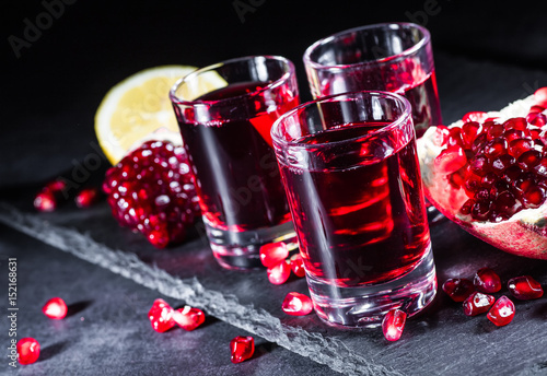 Fresh red juice cocktail with pomegranate seeds and ice