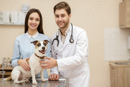 Fototapeta Naklejka Na Ścianę i Meble -  Beautiful young woman at the vet examination with her dog