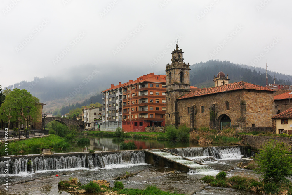 Obraz premium Church with river and waterfall in foreground of Balmaseda, Bizkaia, Basque Country, Spain