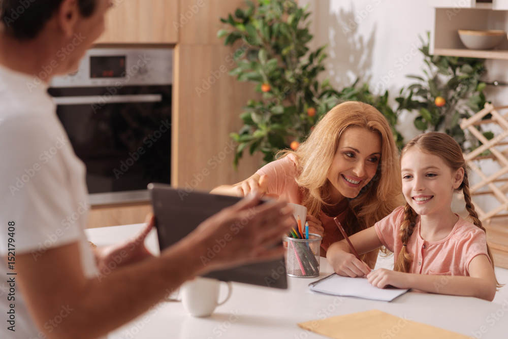 Fototapeta premium Loving parents enjoying painting with little daughter at home