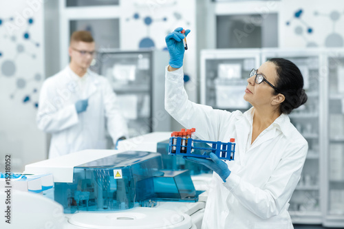 Senior woman professional chemist working with blood samples at the modern laboratory