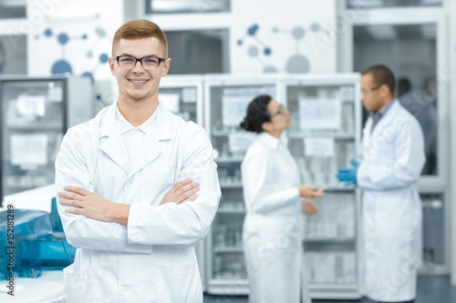 Cheerful chemist posing proudly at the laboratory