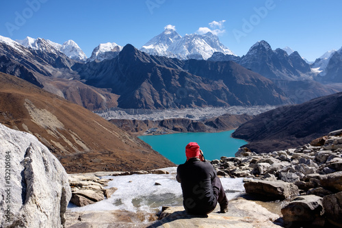 A man is sitting and enjoying view of Mount Everest, the highest mountain in the world, from nearby Renjo La Pass photo