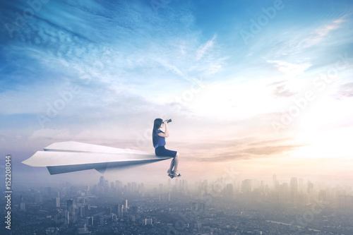 Tableau sur toile Businesswoman sitting on paper aeroplane