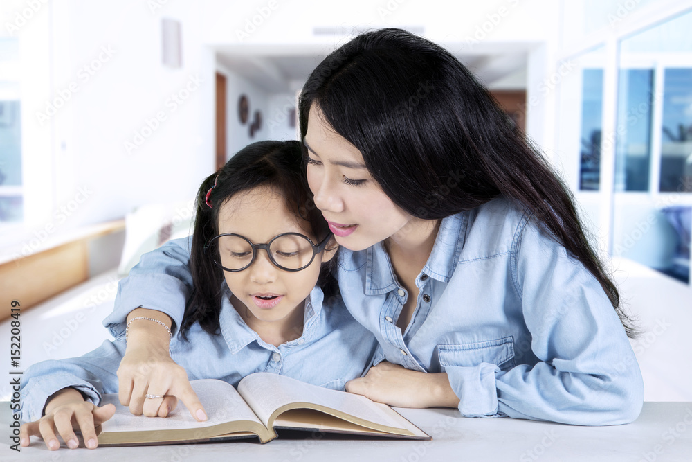 Child and her mother read a book
